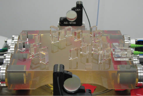 Figure 2 The hydroxide catalysis bonded optical bench interferometer for LISA Pathfinder. The top surface of the Zerodur baseplate is ∼20 cm square and there are 22 bonded optical components and two bonded fibre injectors. Image reproduced from [50].