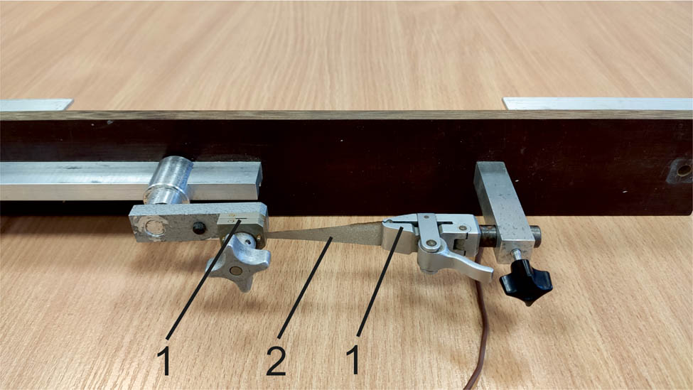 Figure 3
Clamps (1) with tested fabric mounted (2).