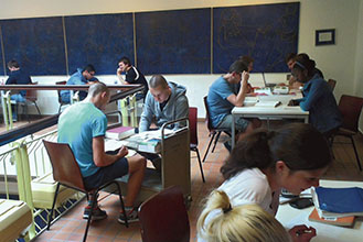 Abb. 1:  Alltag im Treppenhaus der UB Gießen – mehr Gruppenarbeitsräume stehen auf der Wunschliste ganz oben. Und – finde den Fehler: Notfalls tut es auch ein Bücherwagen (Foto: C. Martin-Konle). 