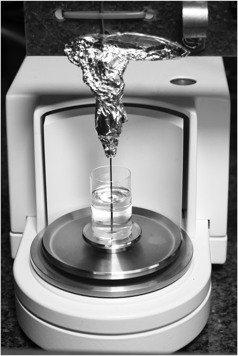 Figure 4:
Gravimetric setup at DTI. Weighing scale with a glass beaker and the immersed needle in water with an oil layer on top of it.