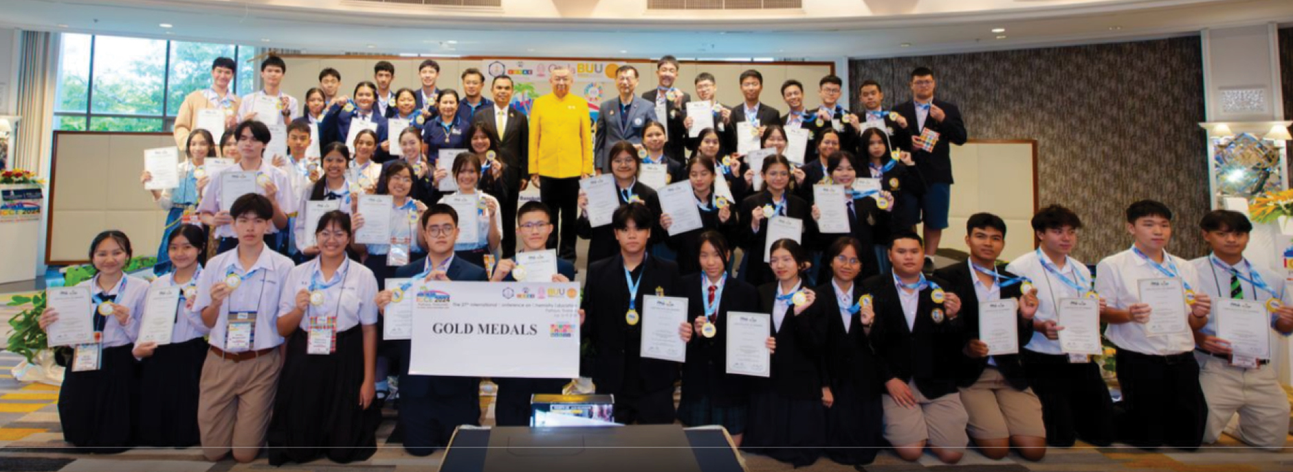  
          Students proudly display their Gold Awards after receiving them from the Minister of Education of Thailand.
        
