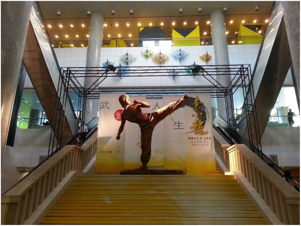 Figure 3: 
					An image of the statue of Bruce Lee showing the stairway leading to it (™ & © Bruce Lee Enterprises, LLC. All Rights Reserved. Designed and Produced by Chu Tak Shing).
				