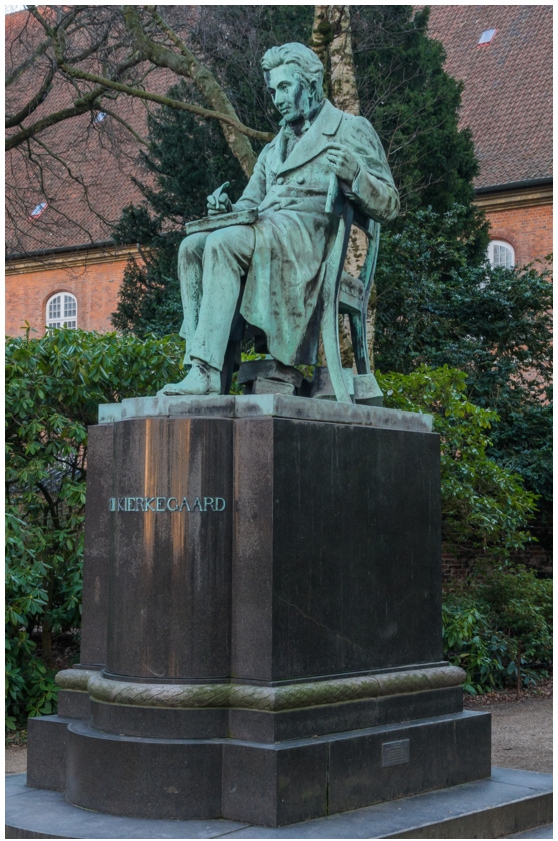 Abb. 1
Søren Kierkegaard-Denkmal im Garten der Königlichen Bibliothek in Kopenhagen mit der von Louis Hasselriis geschaffenen Statue. Quelle: https://commons.wikimedia.org/wiki/File:Kirkegaard_statue_Hasselriis_Copenhagen_Denmark.jpg (Ausschnitt), public domain.