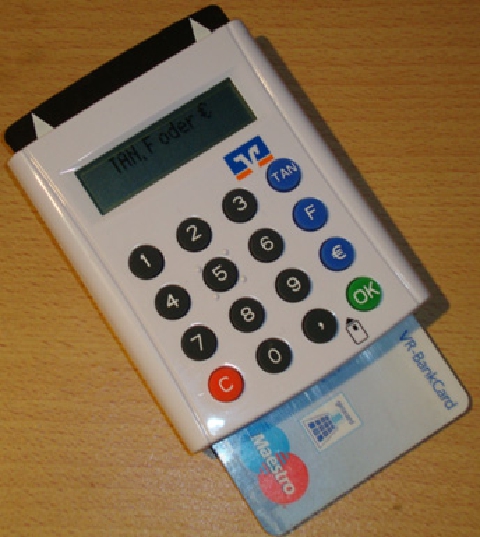 Figure 4 
              A SmartTAN Optic TAN generator from a German bank. The customer’s card is inserted into the device, transaction data is transmitted through optical sensors by holding the token in front of a flickering code on screen. As a fallback mechanism, the data can also be entered through the device’s keypad. After the relevant transaction data is displayed on the screen and acknowledged by the user, the device eventually displays the TAN.
            