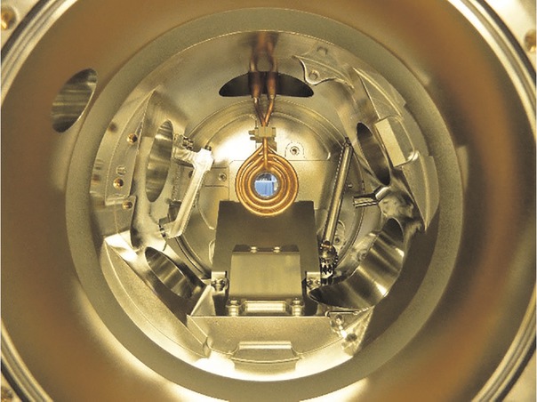 Fig. 1 Top view of the ISS-EML process chamber. The induction coil for heating and positioning is shown in the centre. The rf-feedthroughs for heating and positioning are located above the induction coil. Photograph with curtesy of Dr. W. Soellner, Airbus DS.