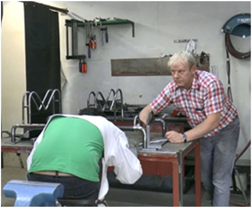 Figure 1: 
Instructor asks and looks at trainee, who is still gazing at welded pipe.
