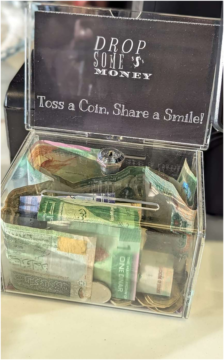 Figure 5: 
A message written on a tip box in English “Toss a coin, share a smile”.
