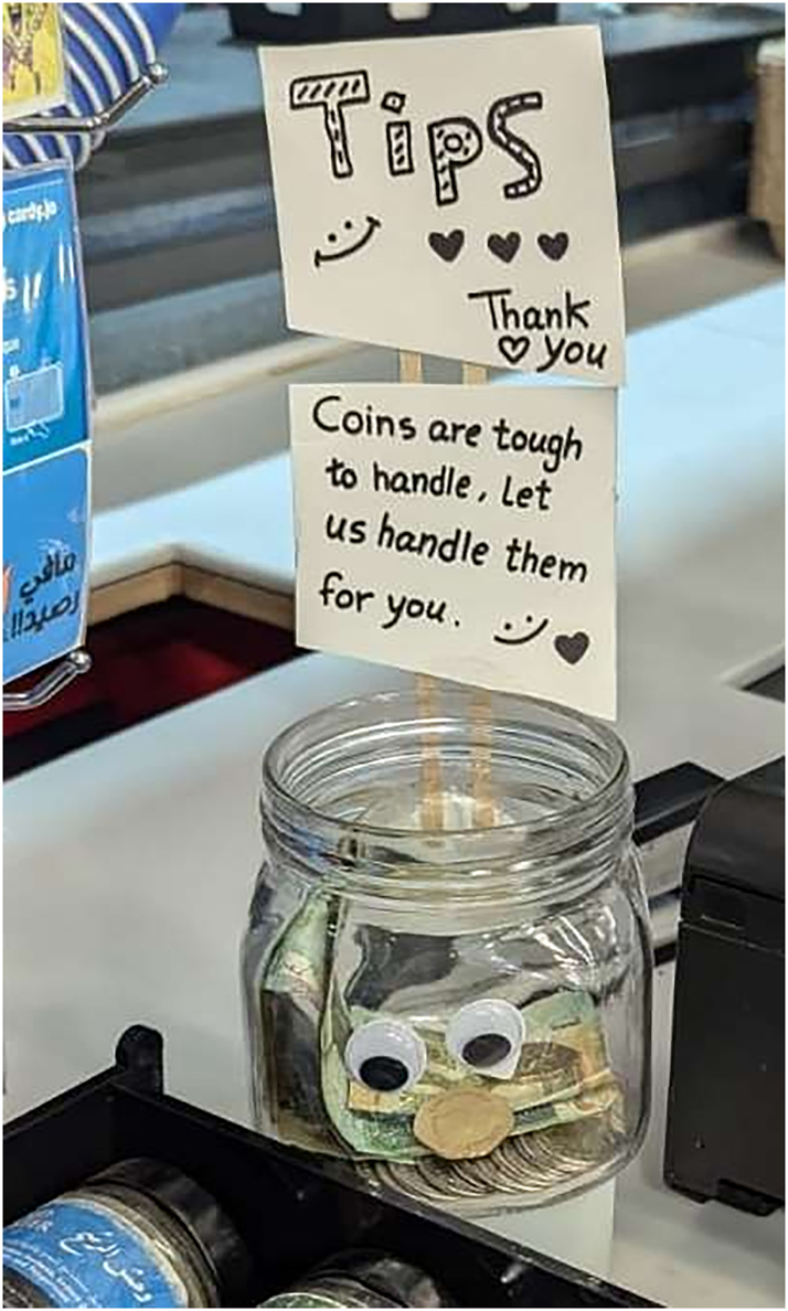 Figure 7: 
A message on a tip box written in English “Coins are tough to handle; let us handle them for you”.
