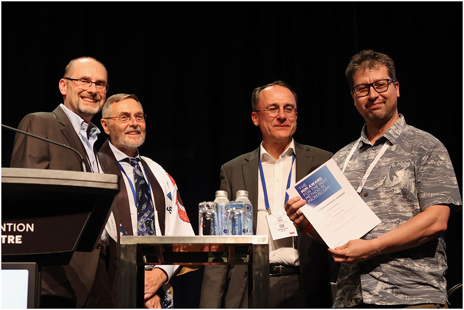  
Felipe Kremer (right) was presented the MIM AWARD for the best method in Microscopy in Bio/Life Sciences at the APMC13 conference dinner by Martin Friedrich, Roger Wepf, and Andreas Thoss (from left to right) (Photo with courtesy of Peter Hines).

