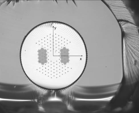 Figure 1 Optical micrograph of the DC-200/40-PZ-Yb fiber, consisting of a 40 µm diameter Yb-doped index-neutral core, 200 µm pump cladding, and large stress applying parts that create a polarizing waveguide structure i.e., only one transversal mode with one polarization can propagate. The outer diameter is ~450 µm, which effectively reduces microbend loss.