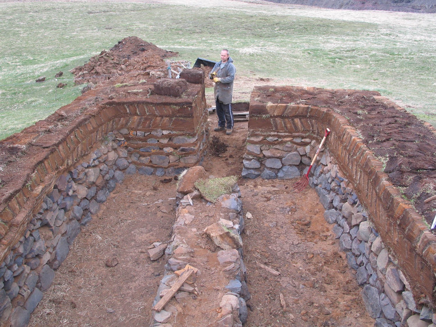 Figure 7
Helgi Sigurðsson, a master craftsman at the entrance of a sheep shed reconstructed by the Heritage Craft School Project at Tyrfingsstaðir, North Iceland. The walls have a classic construction commonly found in animal housing. Alternating turf and stone halfway up the walls protect them from being damaged by animals. The upper part of the wall is a classic double-faced wall made of clamped blocks. Photo: Bryndís Zoëga.