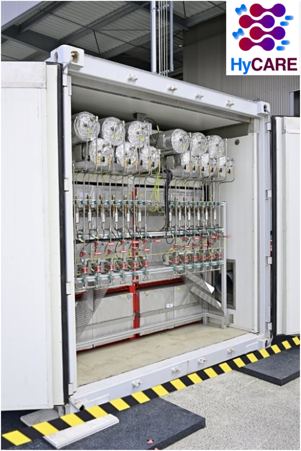 Fig. 4: 
Hydrogen storage system developed in HyCARE project: Cylinders at the top contain the metal hydride for hydrogen storage and boxes at the bottom contain the PCM for heat storage.
