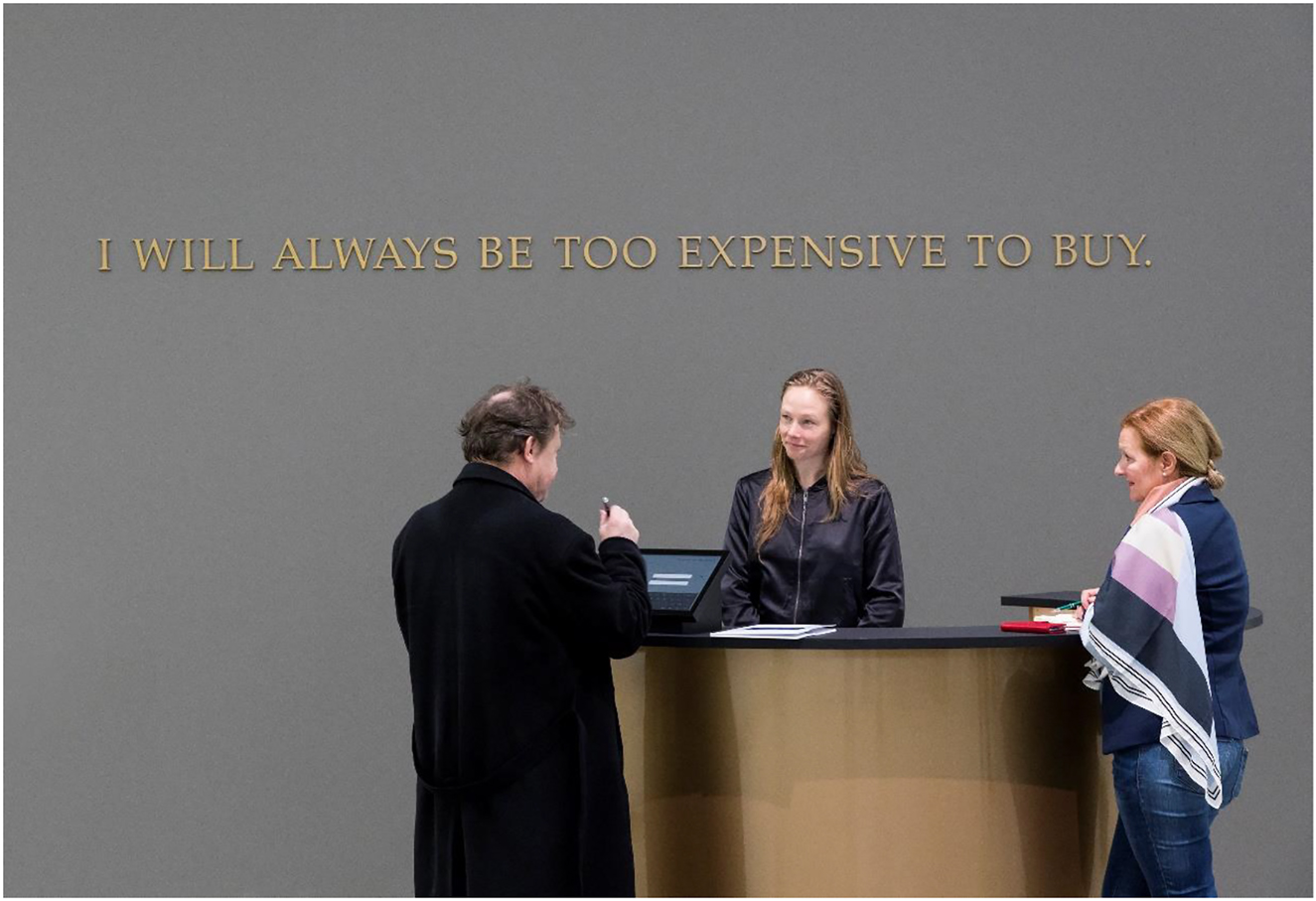 Figure 2: 
Adrian Piper, The Probable Trust Registry: The Rules of the Game #1–3, 2013. Installation + Participatory Group Performance: three embossed gold vinyl wall texts on 70% grey walls; three circular gold reception desks, each 72 “Ø × 42” (182,88 cm × 106,68 cm); contracts; signatories’ contact data registry; three administrators; self-selected members of the public. Detail: The Rules of the Game #1. Collection Staatliche Museen zu Berlin, Nationalgalerie. © Adrian Piper Research Archive (APRA) Foundation Berlin. Photo credit: David von Becker.
