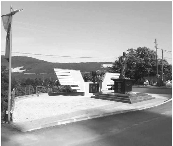 Figure 9 The monument dedicated to Aqif Krosi in Reçani, with a wreath of flowers. Behind the statue, adorned with the double-headed Albanian eagle, is the memorial plaque of those killed in 1913.