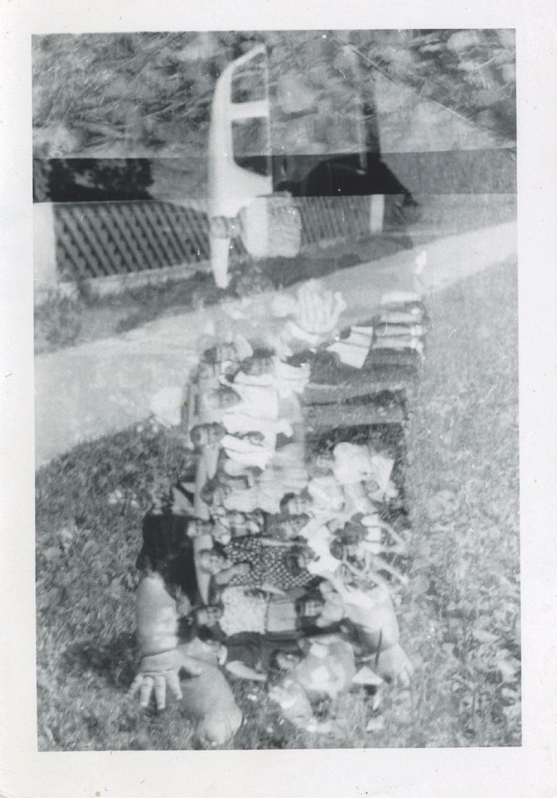 4 
A baby sits in the grass, its features obscured by the group photo in fig. 3, photographer unknown, c. 1950s. Author’s personal collection