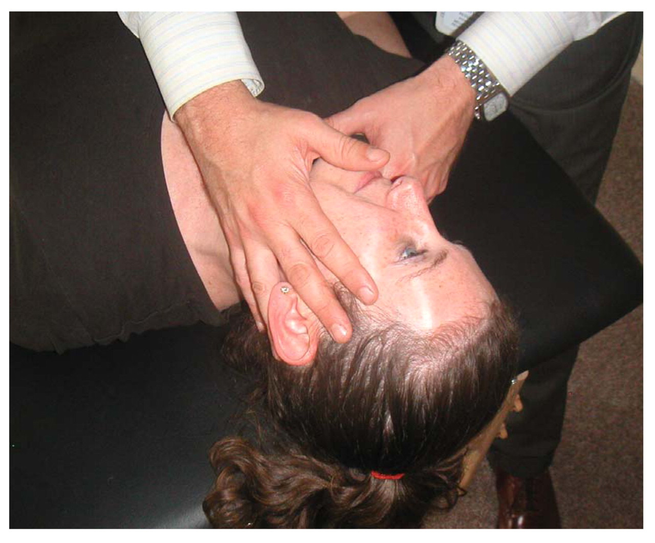 Figure 2.
To perform the mandibular drainage technique (ie, Galbreath treatment), the osteopathic physician's hand is placed on the patient's mandible to apply an anterior tractional force. This is repeated on both sides.